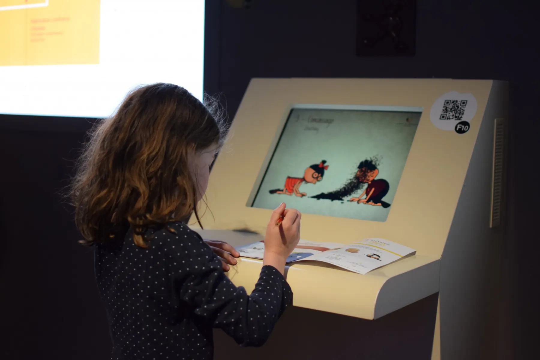 Enfants découvrant les secrets du chocolat avec une borne tactile à la Cité du Chocolat Valrhona